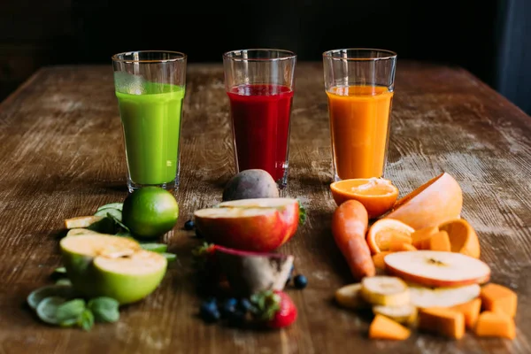 Smoothies orgânicos de frutas e vegetais com ingredientes frescos na mesa