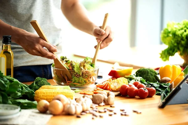 Mulher cozinha salada com legumes