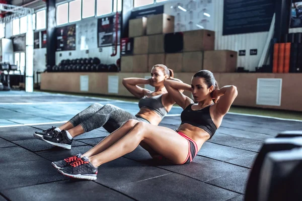 Duas mulheres desportivas a exercitar-se